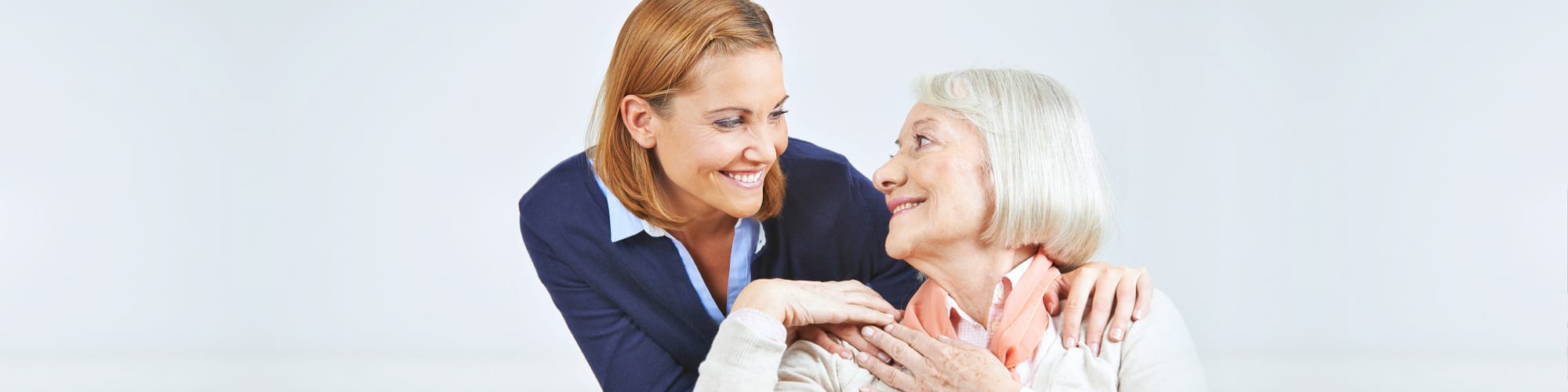 caregiver and senior woman smiling each other